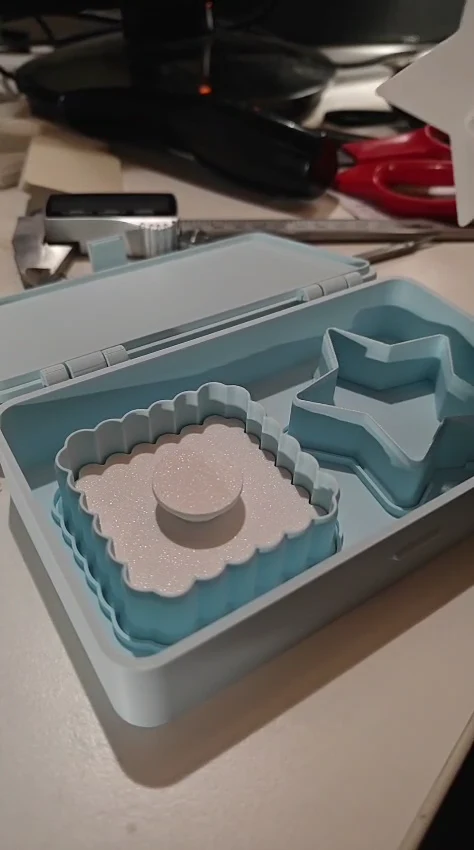 Echt geprinte lichtblauwe koekjesvormen met witte stempels in hun open bewaardoosje